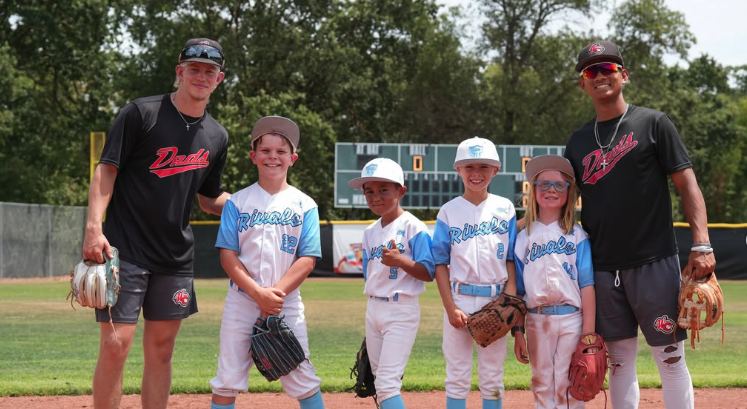Rivals players on the field with two college players